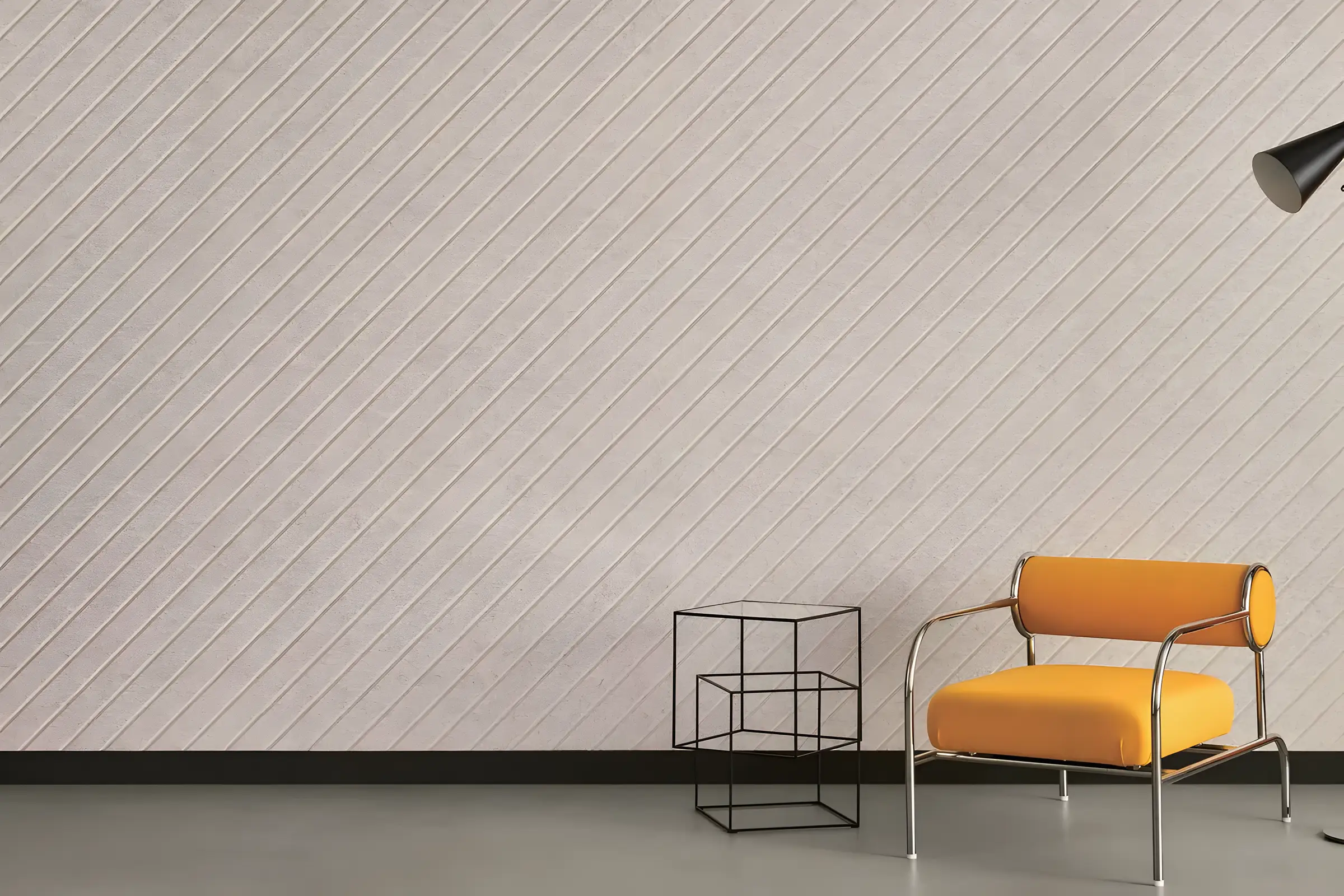 Wall of carved acoustic panels with a diagonal pattern behind an orange armchair